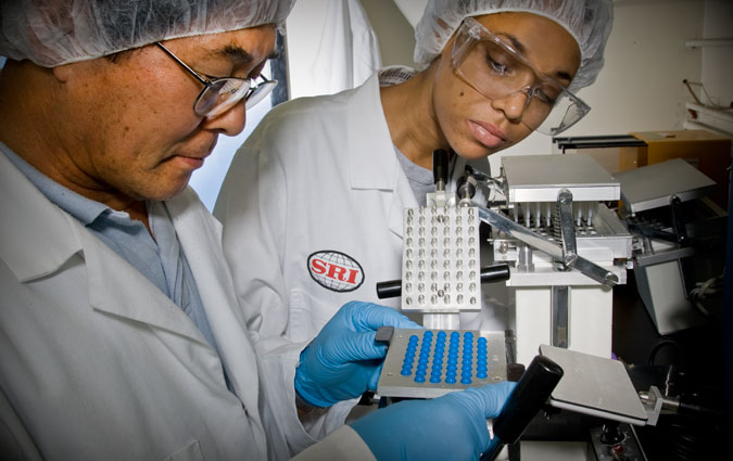 SRI Pill Manufacturing - The use of bright blue and the concentrated focus of both scientists reinforced the message of extreme care, precision, and quality control in the company’s manufacturing process.